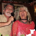 A man and woman singing into microphones.