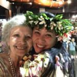 A woman and her mother are smiling for the camera.