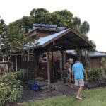 A man and woman standing in front of a wooden structure.