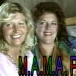 Two women smiling for a picture in front of a camera.