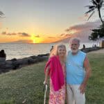 Couple enjoying a tropical sunset by the ocean shore.